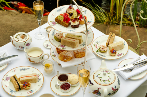 A wide close up shot of Afternoon Tea at the Orangery: the table is set up with an afternoon tea stand and two glasses of champagne