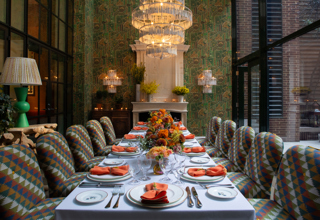 Image of a long table set up for lunch in The Orangery at Crosby Street Hotel.  