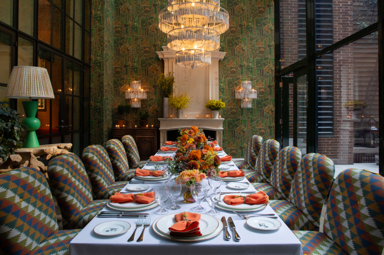 Image of a long table set up for lunch in The Orangery at Crosby Street Hotel.  