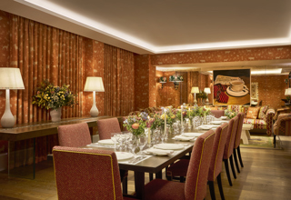Night shot of a long dining table in the Rocklin private events room at Haymarket Hotel