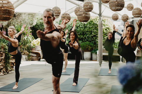 An image of Equinox instructors doing a yoga class to promote the series of classes hosted by Equinox on Ham Yard Hotels Roof Terrace.