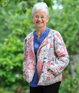 A portrait of author Jacqueline Wilson standing in a garden
