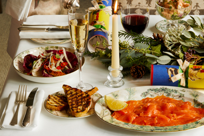 Portrait shot of festive dining set-up with Champagne on Tall Trees bespoke crockery