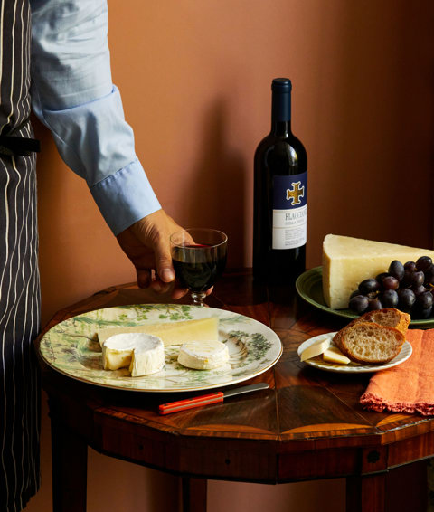 An close up image of a table with multiple different plates with cheeses and wine at The Potting Shed, Dorset Square Hotel. 