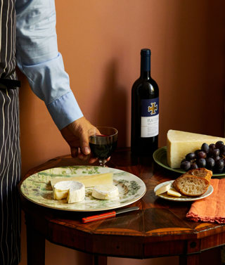 An close up image of a table with multiple different plates with cheeses and wine at The Potting Shed, Dorset Square Hotel. 