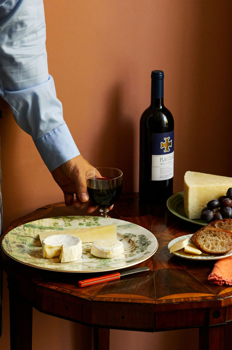 An close up image of a table with multiple different plates with cheeses and wine at The Potting Shed, Dorset Square Hotel. 