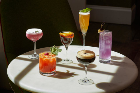 An image of multiple cocktails on a table in The Crosby Bar.