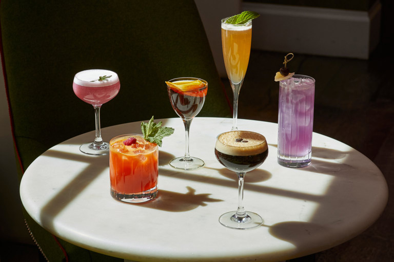 An image of multiple cocktails on a table in The Crosby Bar.