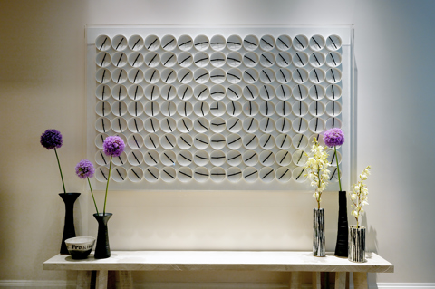 Image of the Million Times rotating clocks in Ham Yard Hotel, above a table with flowers on. 