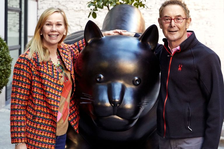 This image shows Kit and Tim Kemp standing next the Botero Cat statue that sits outside Warren Street Hotel in New York. Kit stands on the left smiling with Tim on the right of the statue smiling.