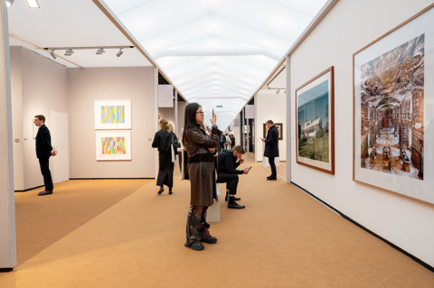 This image is of the inside the fair at frieze, in it we can see people looking at the art collections within the fair. this is being used to promote Ham Yards restaurant pop up with the art fair.