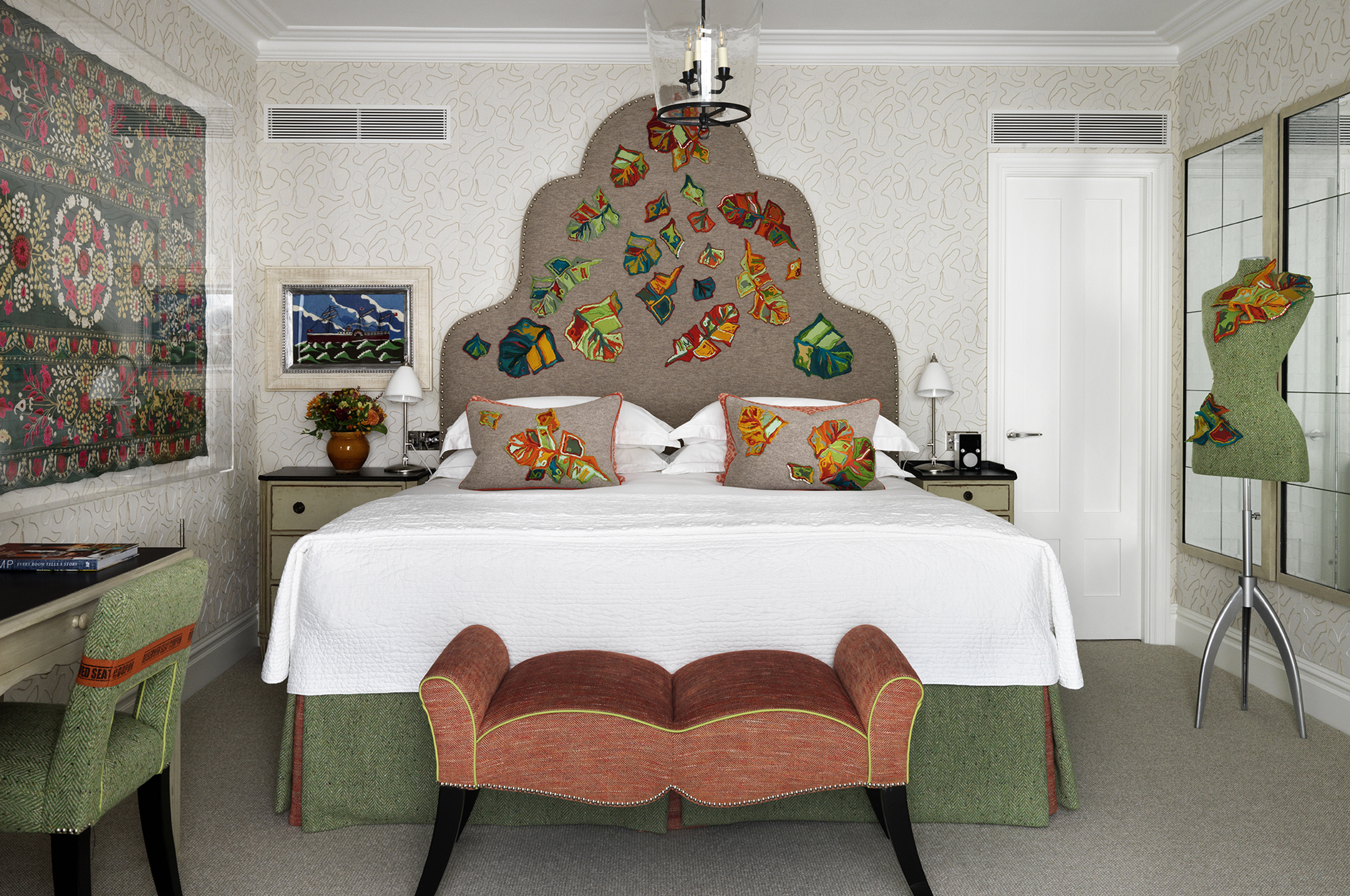Luxurious hotel bedroom with ornate headboard and colorful pillows
