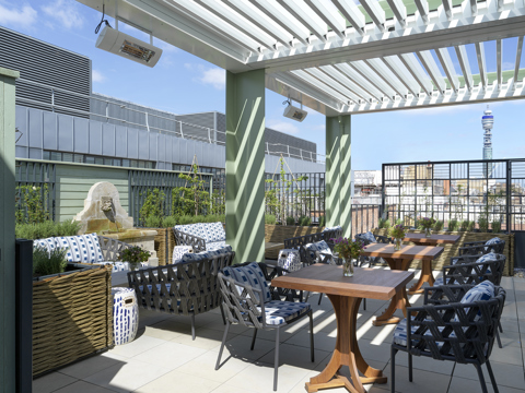 A wide shot of the view of the Roof Terrace top floor featuring lounge seating, occasional tables and views over the Soho skyline at 9-11 Richmond Buildings