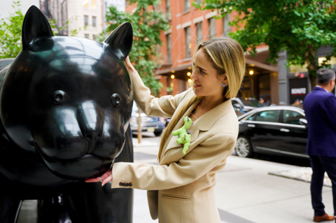 Side angle shot of design director WIllow Kemp, with her hands round the black cat statue. 