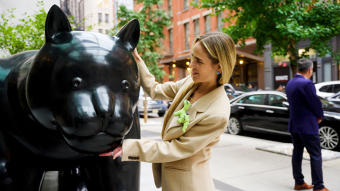 Side angle shot of design director WIllow Kemp, with her hands round the black cat statue.