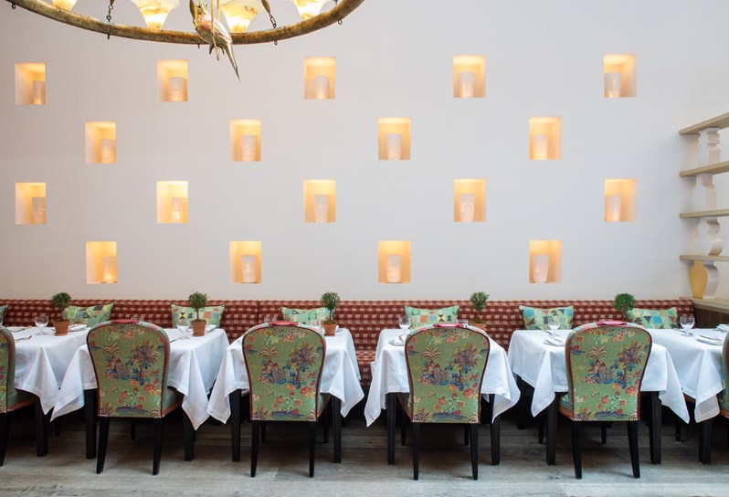 Image of dining tables set-up against the wall with art installation in The Orangery private events room at the Whitby Hotel.