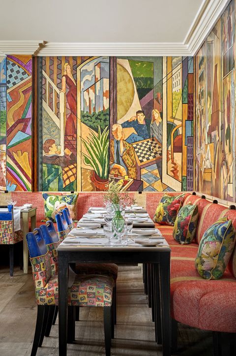 Oscar Restaurant with a colourful mural covering the walls, tables set up with with table cloths, cultery and glasses