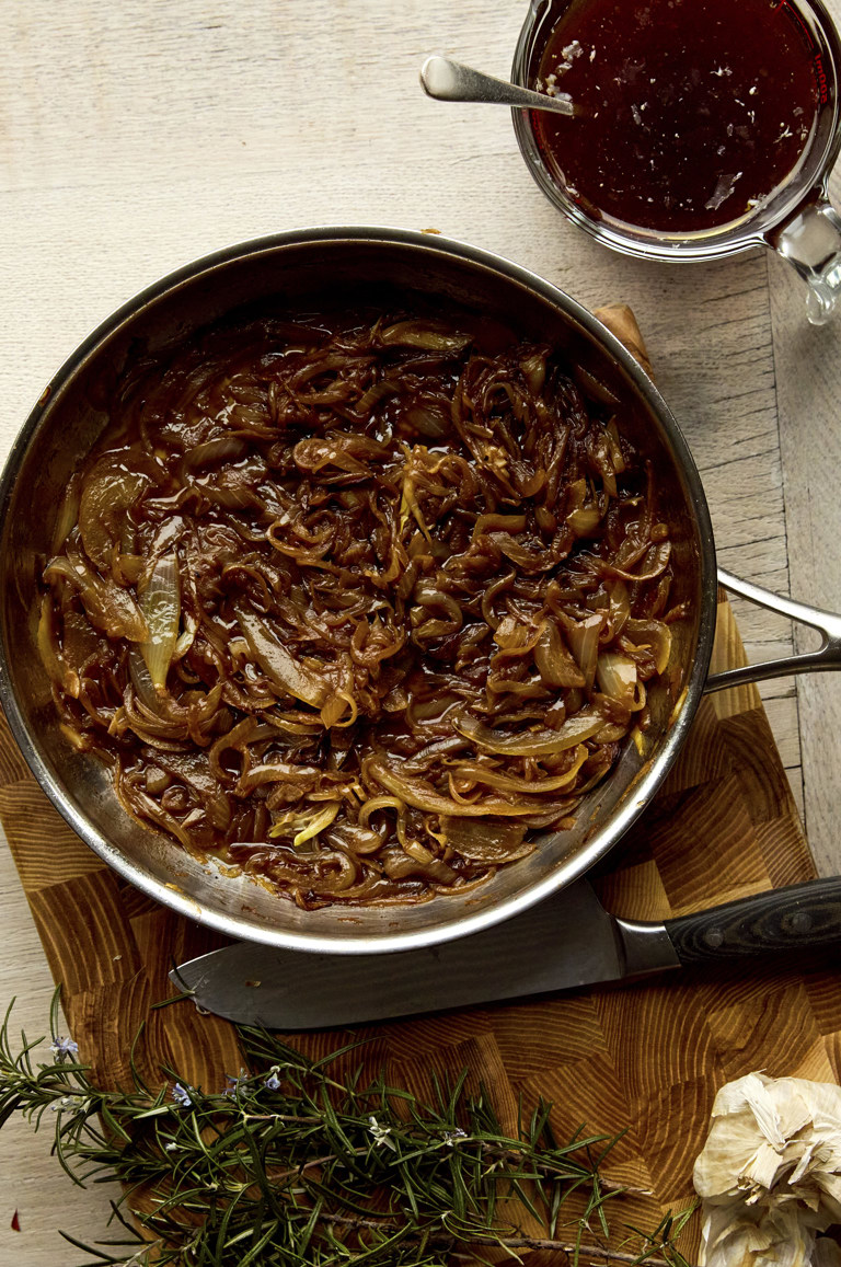 A frying pan filled with sauteed onions shot from above