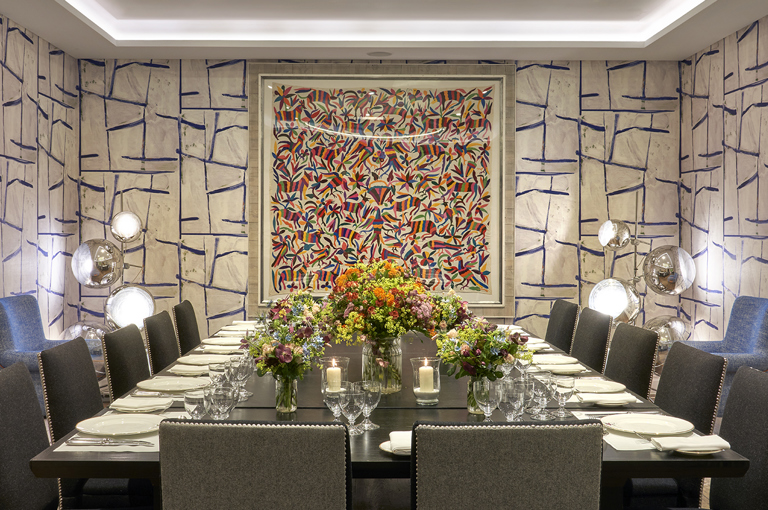 An image of the long dining table set up with flowers in the Sandra Blow, private events room, at The Soho Hotel.