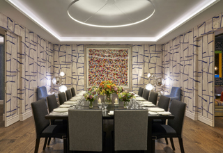 An image of the long dining table set up with flowers in the Sandra Blow, private events room, at The Soho Hotel.