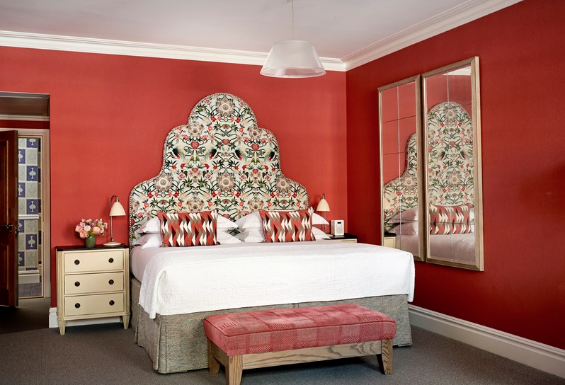 The Bed of Room 108, a Connecting Junior Suite that has bedside tables and mirrors along the wall