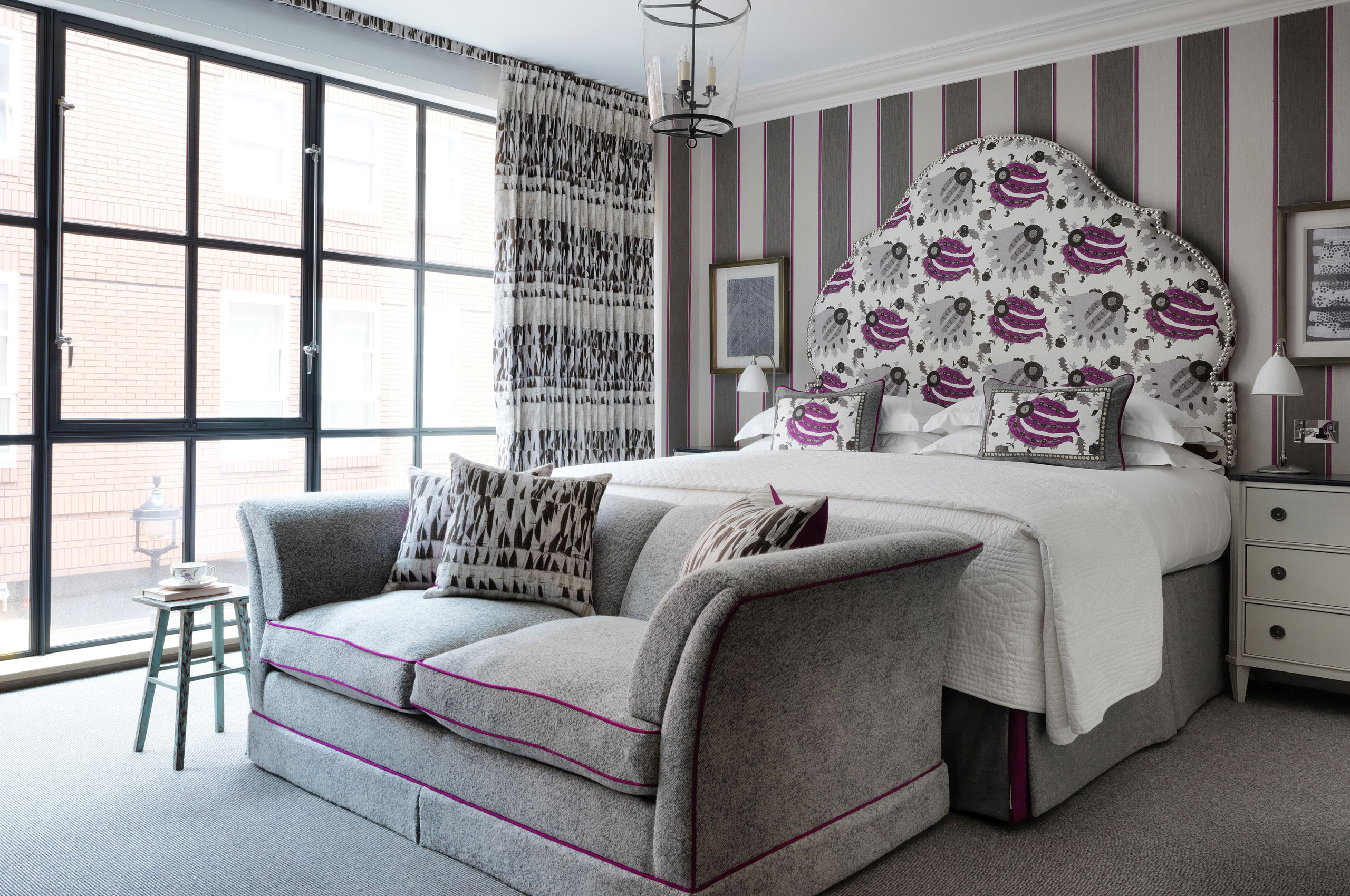 Luxurious hotel bedroom with patterned headboard and modern furnishings