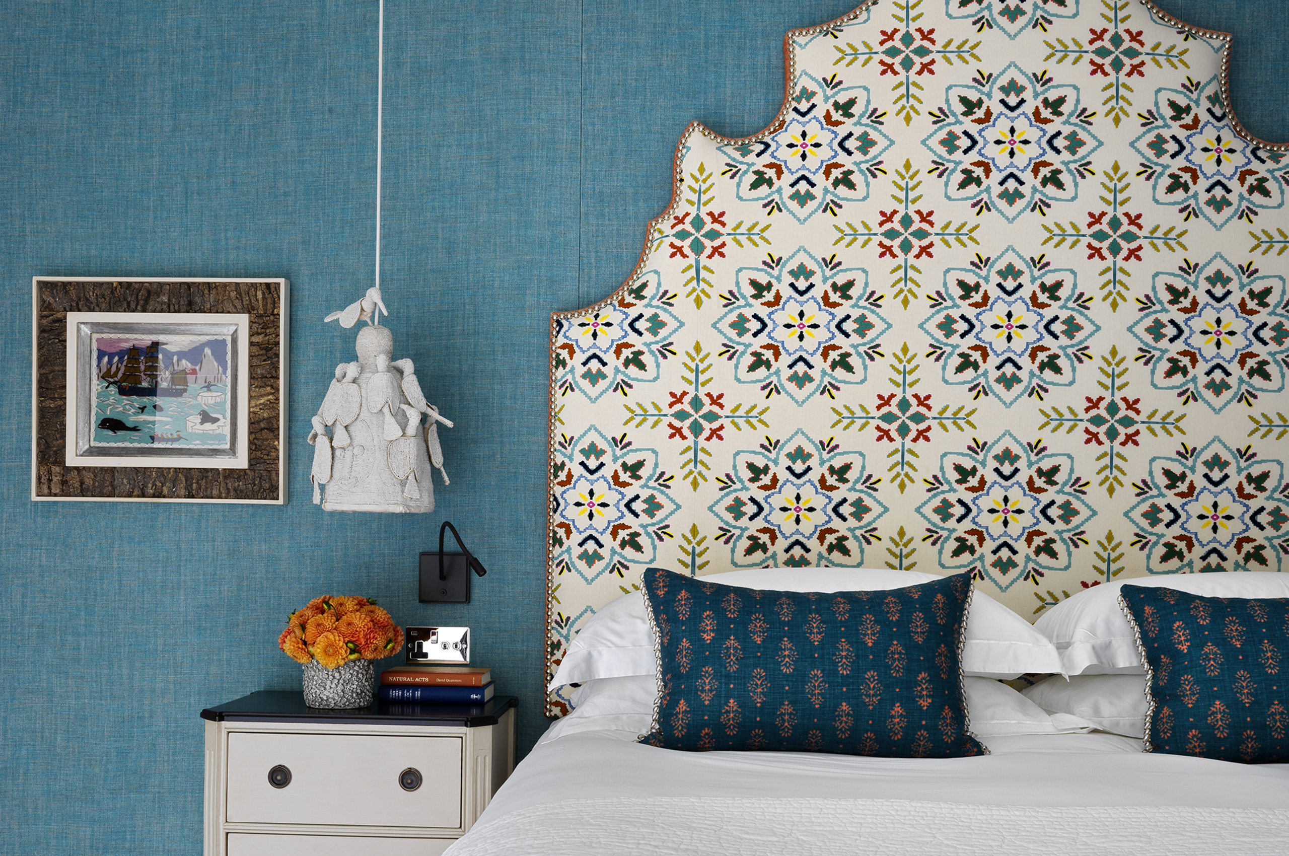 Luxurious bedroom with patterned headboard and teal walls