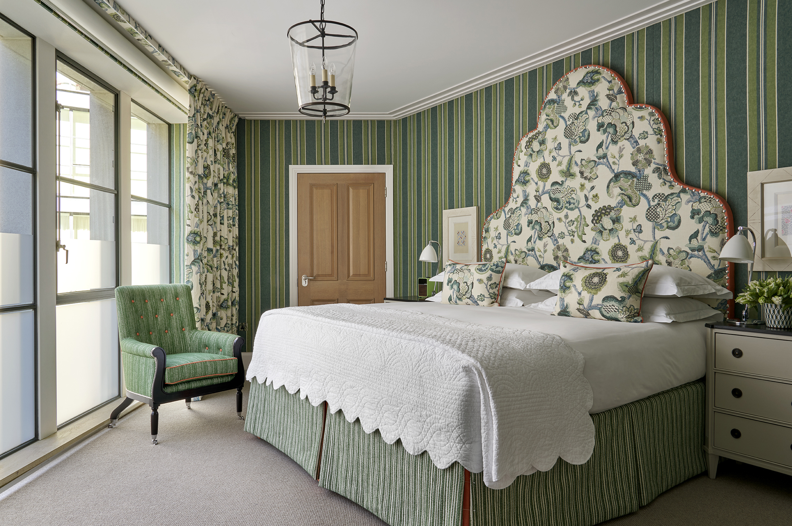 Elegant bedroom with floral headboard and green striped walls