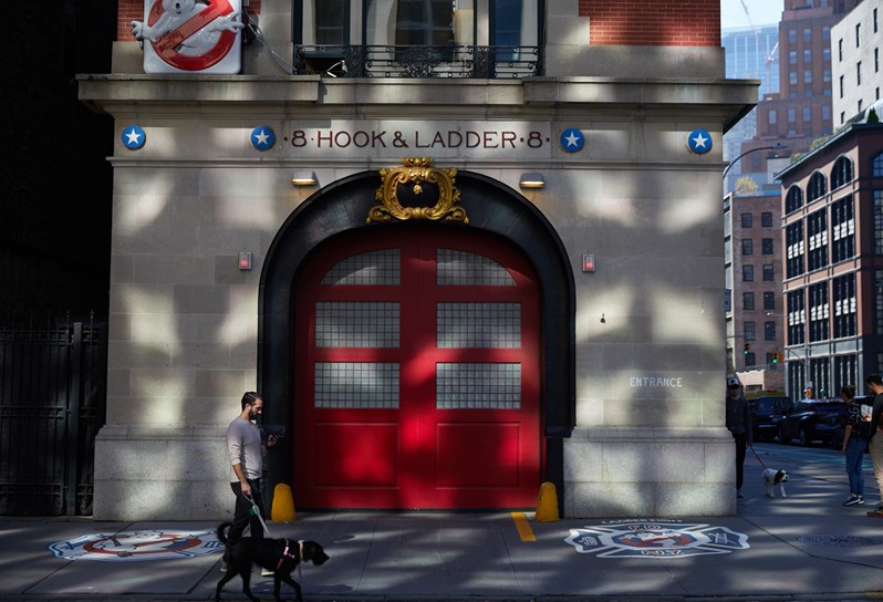 A fire station building in Tribeca with an arched red door and a sign above that reads Hook & Ladder