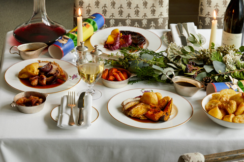 Wide shot of festive dining set-up with wine on Mythical creatures bespoke crockery