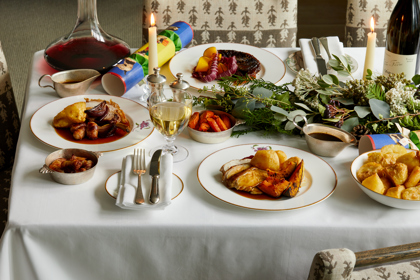 Wide shot of festive dining set-up with wine on Mythical creatures bespoke crockery
