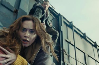 A still from 'Disclosure Day'. A close up of a woman falling towards the camera. A man behind can be seen reaching towards her from a ladder above