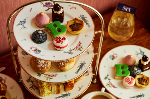 An image of the whole Afternoon Tea Set up with the cakes, sandwiches and cocktails for the Six: The Musical Afternoon Tea at Refuel, Soho Hotel.