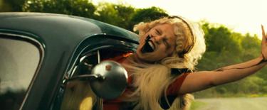 A still from "The Bride" showing a woman leaning out the window of a car. 