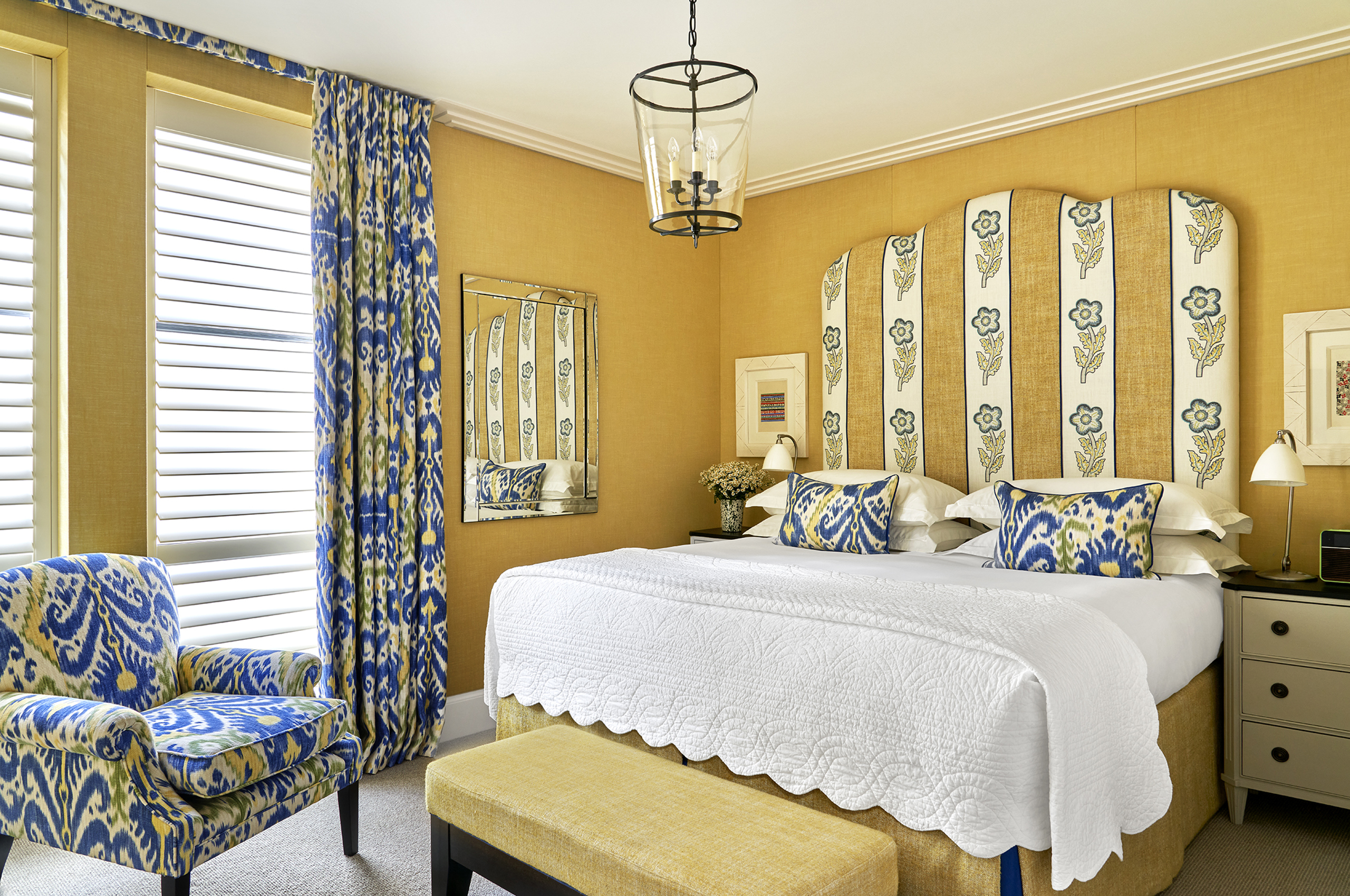Hotel bedroom with patterned bed and armchair