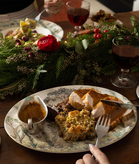 This image shows a festive dining scene at the Warren Street Bar, Warren Street Hotel, featuring a traditional festive roast dish served on Tall Tress Fine Bone China