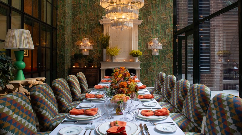 Image of a long table set up for lunch in The Orangery at Crosby Street Hotel.