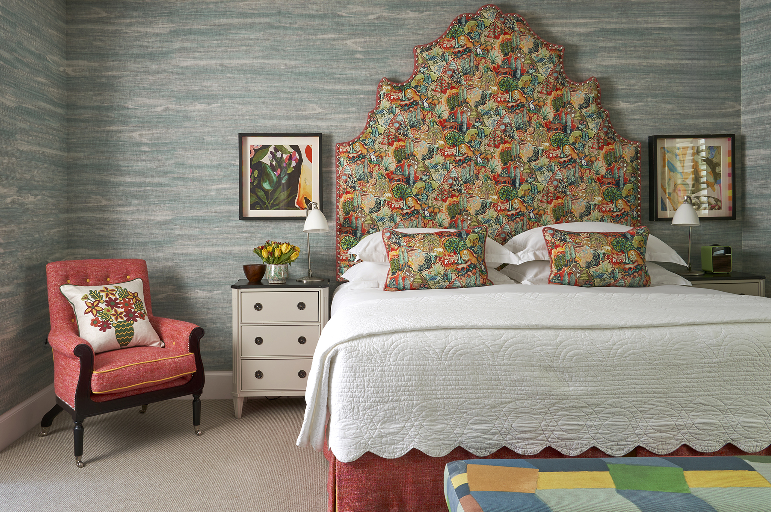 Bedroom with ornate headboard and red armchair