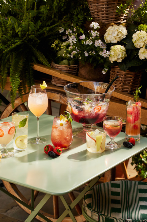 A portrait shot of a selection of Wimbledon cocktails at Ham Yard Bar & Restaurant being served on a table in the courtyard