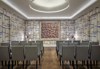 An image of the conference set up, with chairs in rows, in the Sandra Blow private event room, in The Soho Hotel. With 3 rows of 8 chairs across with a break in the middle creating an aisle.