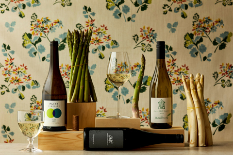 Wide shot of asparagus with wine bottles and glasses