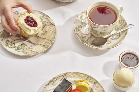 Close shot of cakes from the Traditional Afternoon Tea in the garden with guests at Number Sixteen