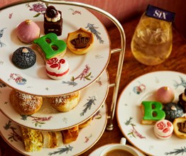 a close up image of the cakes on the afternoon tea stand for the Six: The Musical Afternoon Tea at Refuel, Soho Hotel.