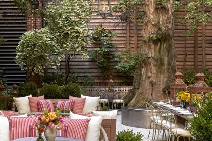 Portrait shot of the long dining table and seating areas in the Sculpture Garden at Crosby Street Hotel