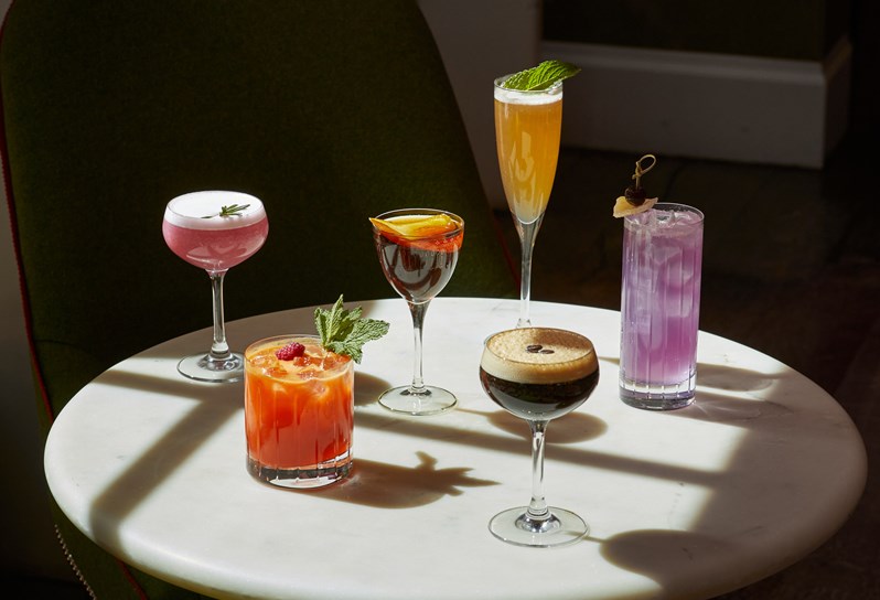 An image of multiple cocktails on a table in The Crosby Bar.