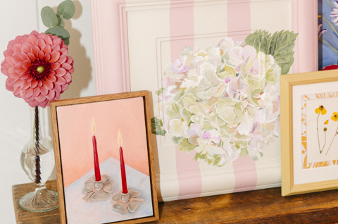 A close up various framed artworks by Domenica Marland on a wooden console table.