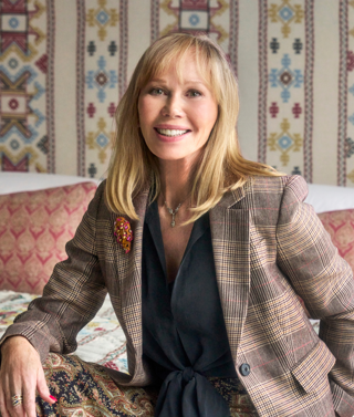 This is an image of Kit Kemp, selected by Kit Kemp, to promote her event 'An Evening with Kit Kemp'. This has been altered using Canva to add a background the same as the website so it can be used as a landscape. 