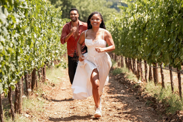 A still from the film "You, Me & Tuscany": the image shows a man and a woman running through a vineyard