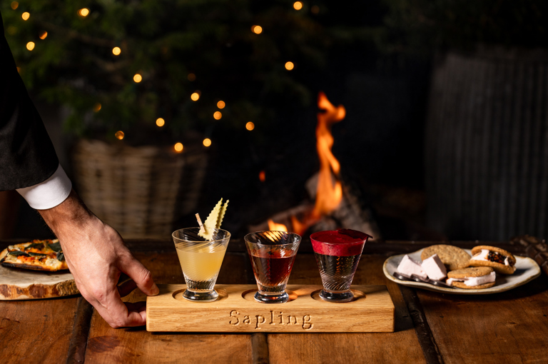 A flight of three cocktails are placed on a table