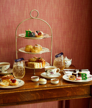 An image of the whole Afternoon Tea Set up with the cakes, sandwiches and cocktails for the Six: The Musical Afternoon Tea at Refuel, Soho Hotel.